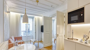 A modern kitchen with a Bosch microwave, a sink, and a dining area with a table and chairs.