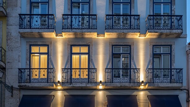 A multi-story building with balconies, awnings, and a restaurant named Mimosa.