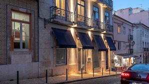 A multi-story building with balconies, large windows, and awnings.