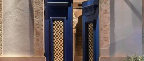 A boutique hotel entrance with a dark blue door and a black awning displaying the name "BOUTIQUE CHIADO".