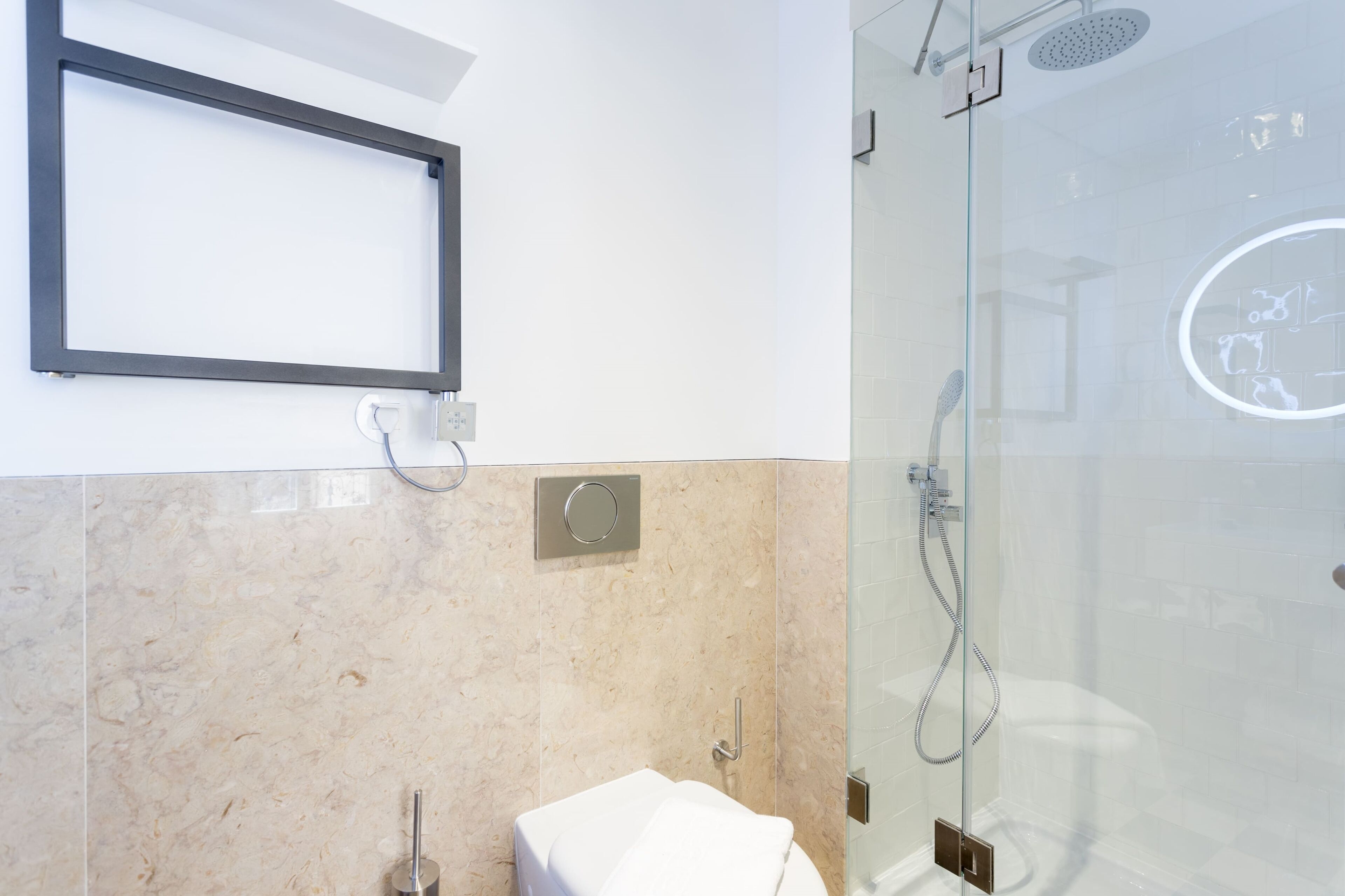 A modern bathroom with a glass shower enclosure, a white sink, and a mirror on the wall.