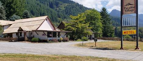 A motel named Paradise Village with a rustic building and a signboard.