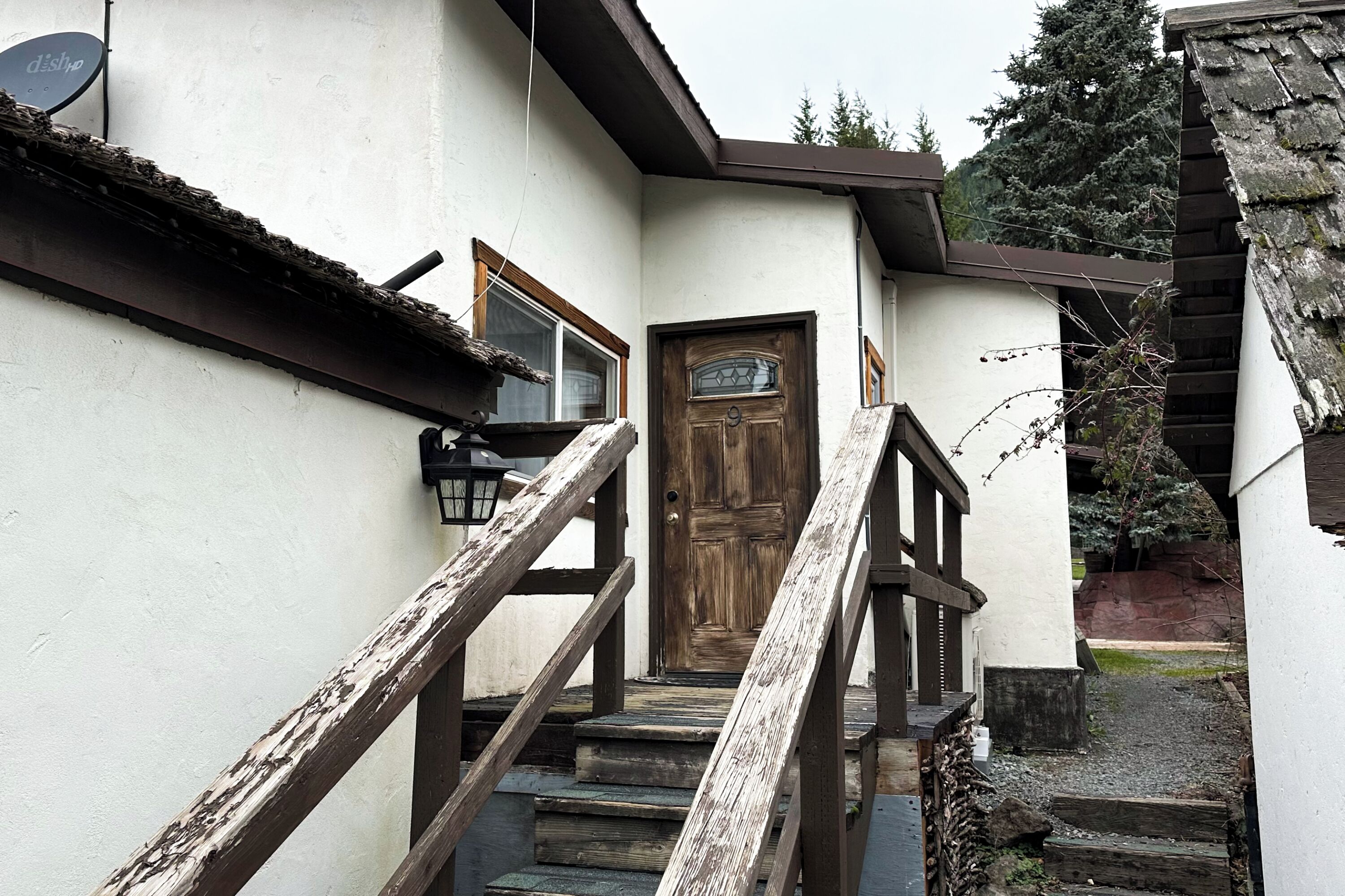 A wooden staircase leading to a door with a window above it.