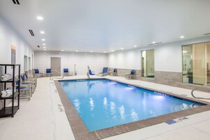 Una piscina techada, sillones reclinables de piscina