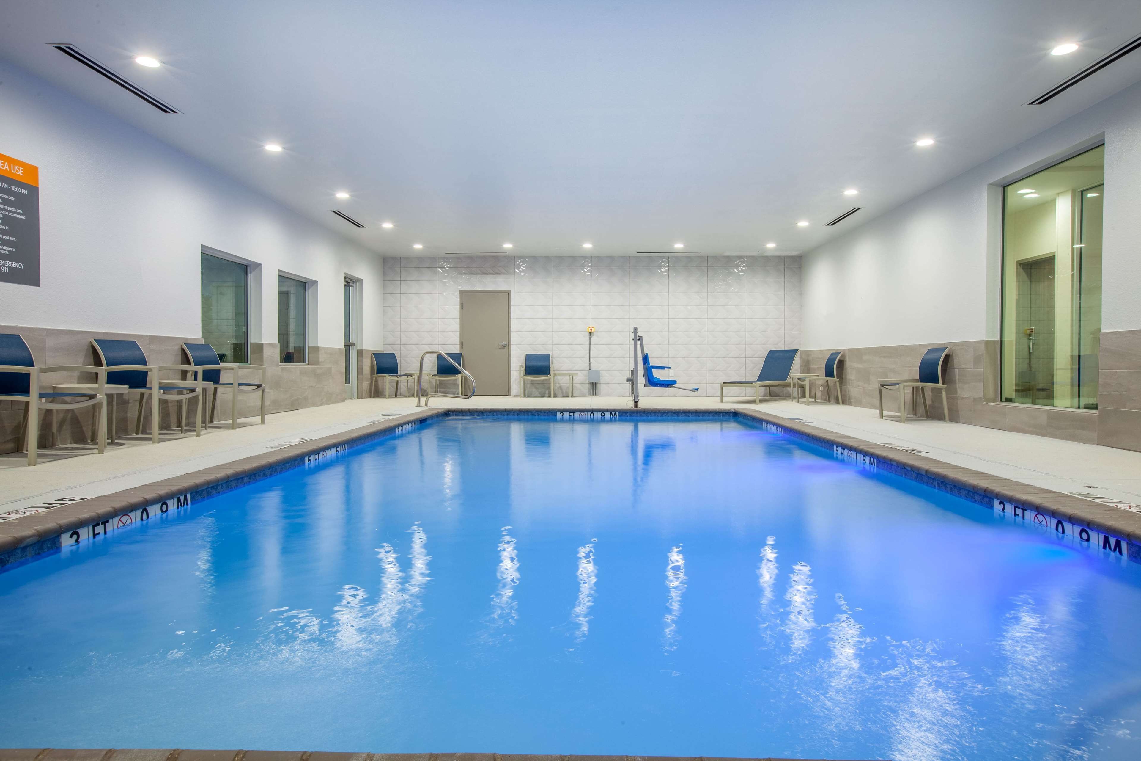 Una piscina techada, sillones reclinables de piscina