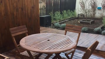 A wooden deck with a round table and four chairs.