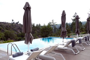 Utomhuspool, parasoller och solstolar