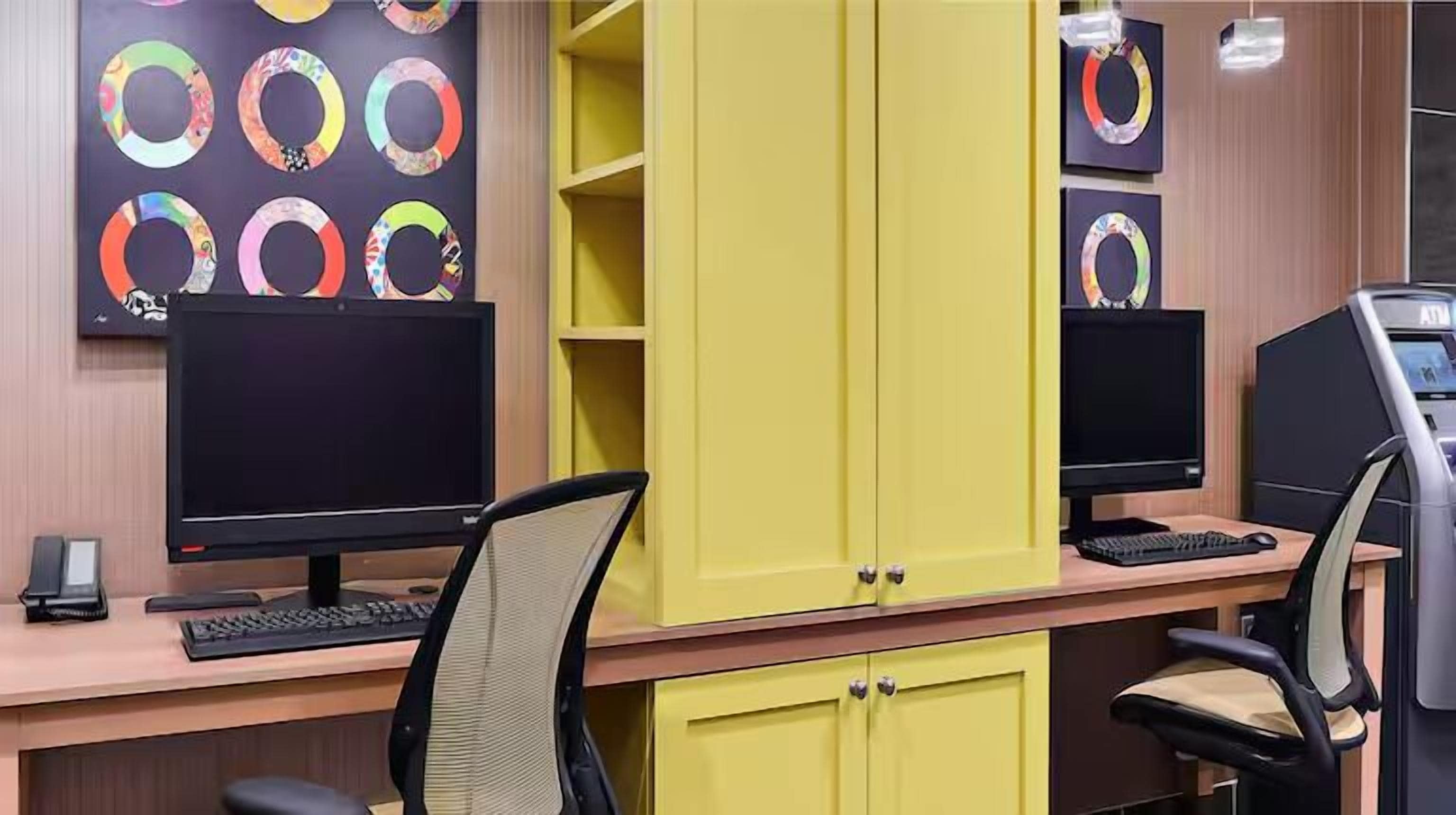 A workspace with two computer monitors, a keyboard, and a chair.
