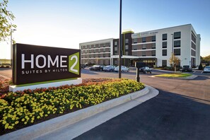 A hotel sign with "HOME 2 SUITES BY HILTON" and a building with multiple floors and parking in the background. - Home2 Suites by Hilton Lagrange (LaGrange)