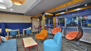 Un espace de détente moderne offrant différents types de sièges, notamment des canapés, des fauteuils et des chaises suspendues.