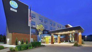 Un hôtel moderne, reconnaissable à son grand panneau « Tru Hilton », doté d’une entrée bien éclairée et agrémenté d’un jardin paysager.