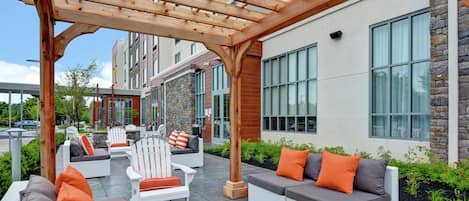Un espacio al aire libre con zona de estar y una estructura de pérgola.