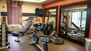 A gym with cardio machines, weight machines, and a mirror reflecting the equipment. - Hampton Inn & Suites Gallup (Gallup)