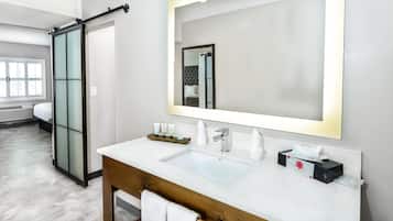 A modern bathroom with a large mirror, two sinks, and a towel rack.