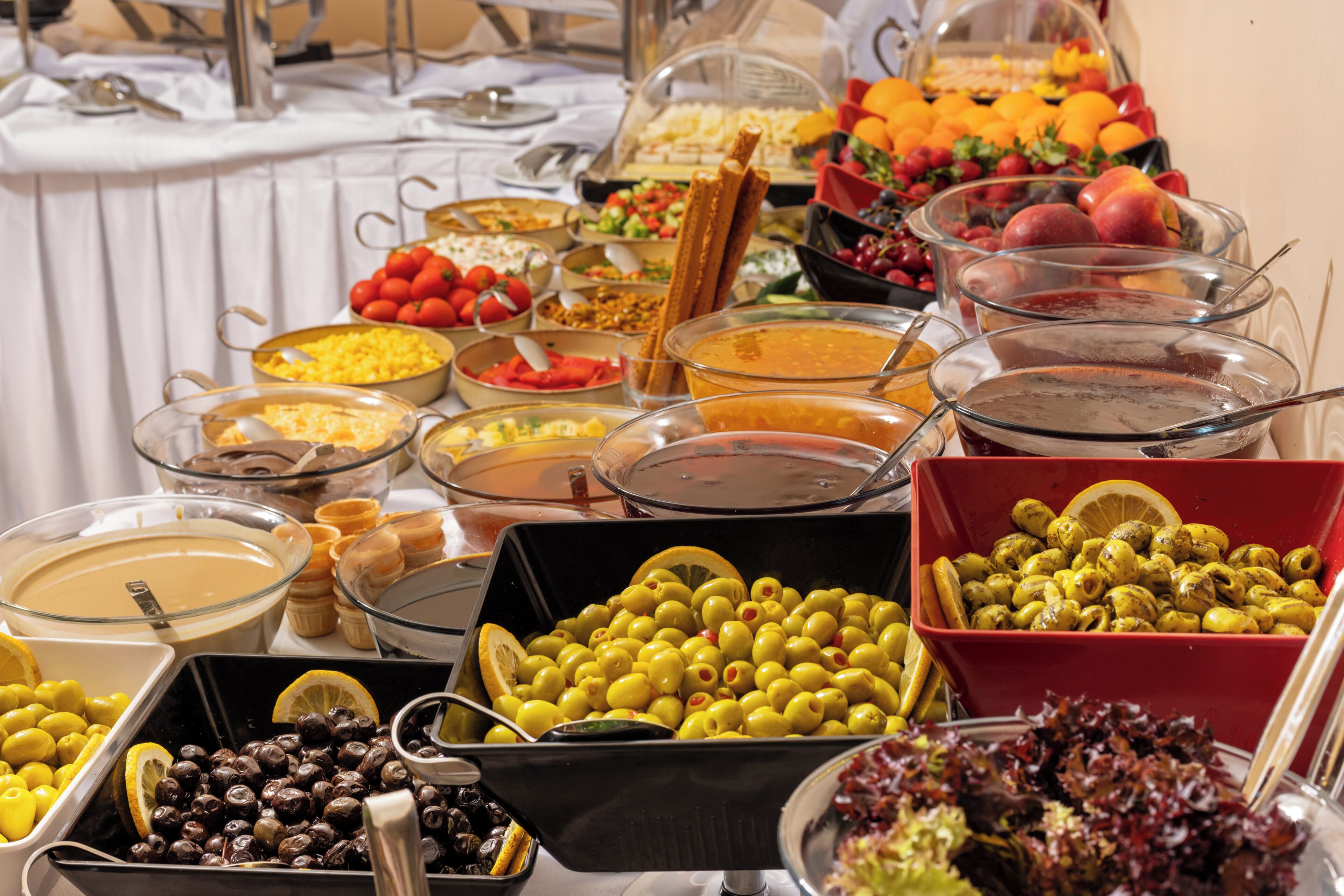 Un buffet proposant une variété d’aliments, notamment des fruits, des légumes et différents types de tartinades.