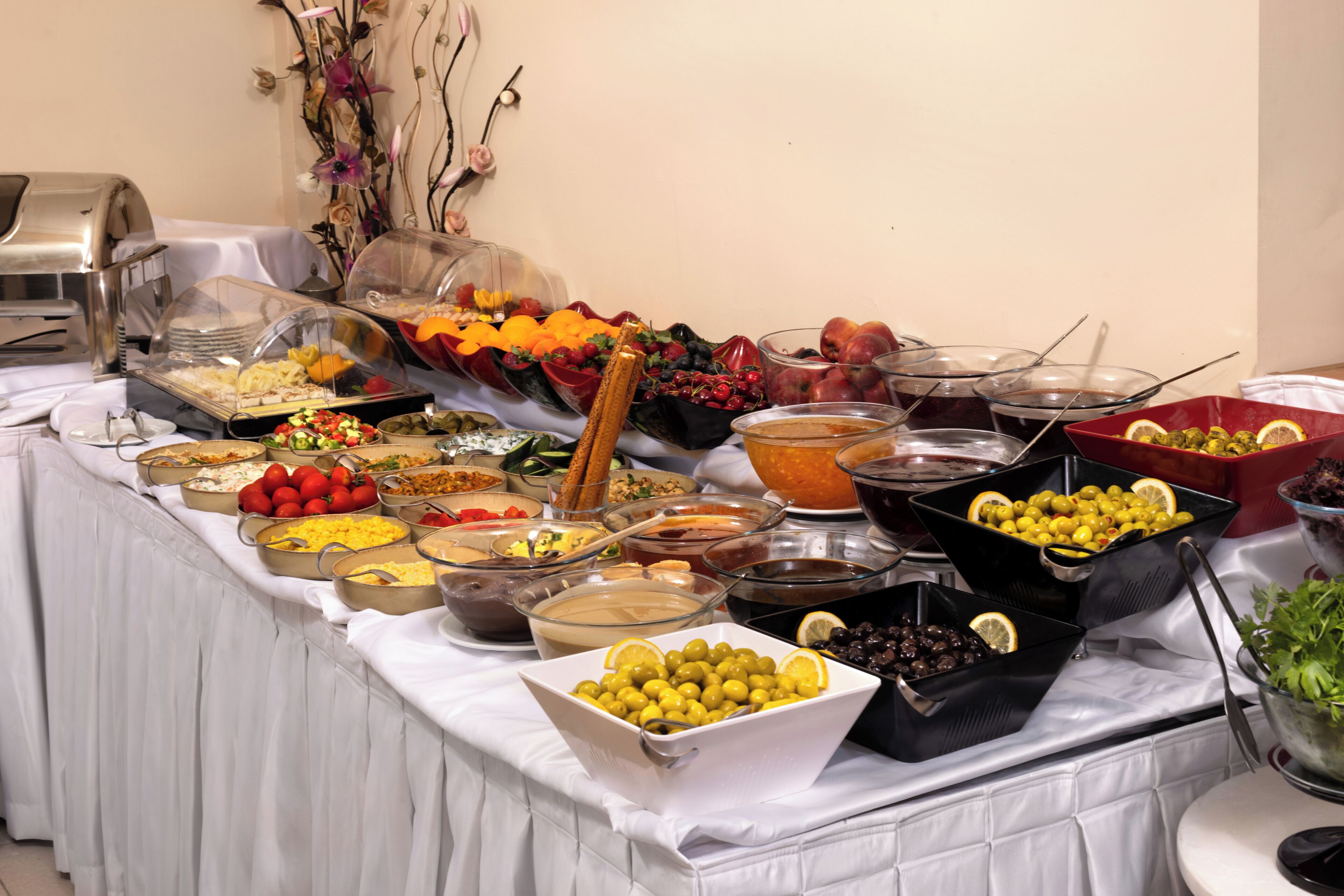 A buffet table with various food items and a coffee station.
