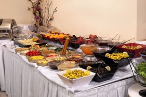 Une table de buffet proposant divers plats et un coin café.