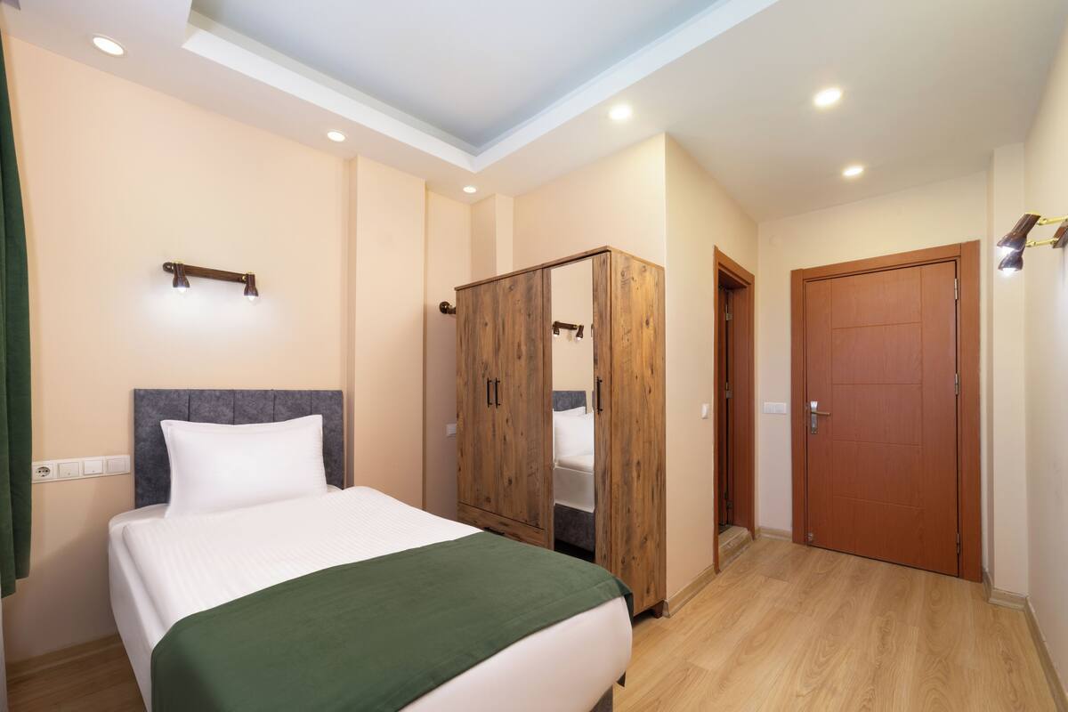 Ein Schlafzimmer mit einem Bett, einem Kleiderschrank und einer Tür.