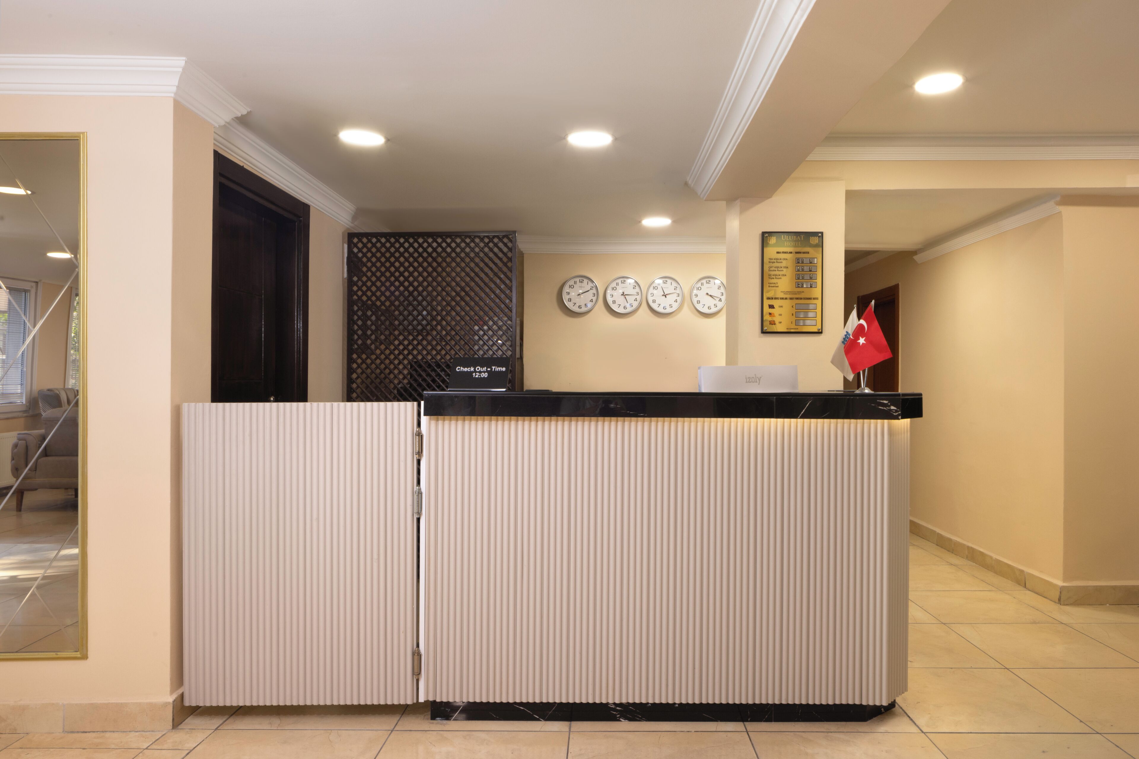 A reception desk with a check-out counter, a wall clock, and a flag.