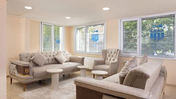A modern living room with a sofa set, two side tables, and a radiator.