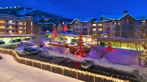 A hotel with multiple buildings, a parking area, and snow-covered surroundings. - Chateau Chamonix - Cx326 Condominium (Steamboat Springs)