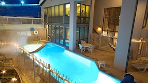 An indoor swimming pool with a fenced area, lounge chairs, and a covered seating area with tables. - Chateau Chamonix - Cx326 Condominium (Steamboat Springs)