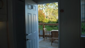A door with the number 8, leading to a wooden deck with chairs and a table. - Harbourview Motel & Accommodations (Port Hawkesbury)