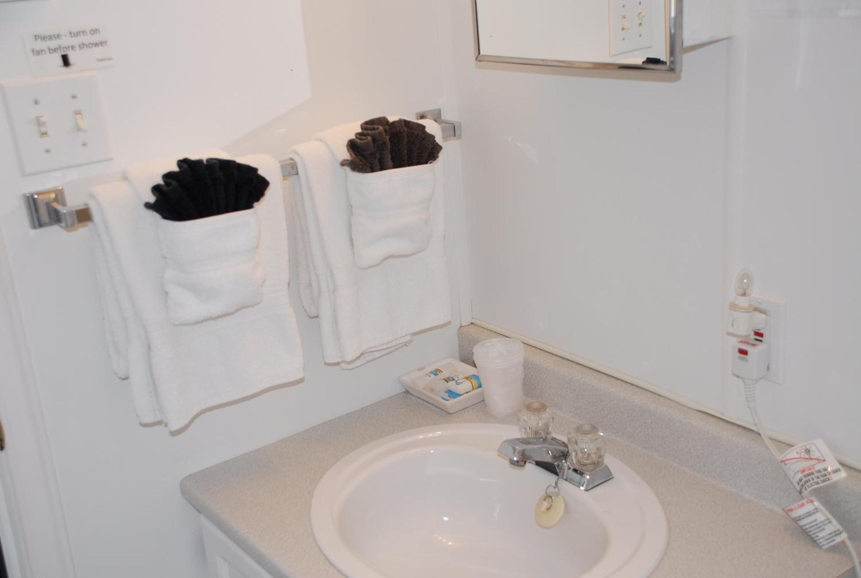 Een badkamer met een wastafel, handdoekhouder en een spiegel.