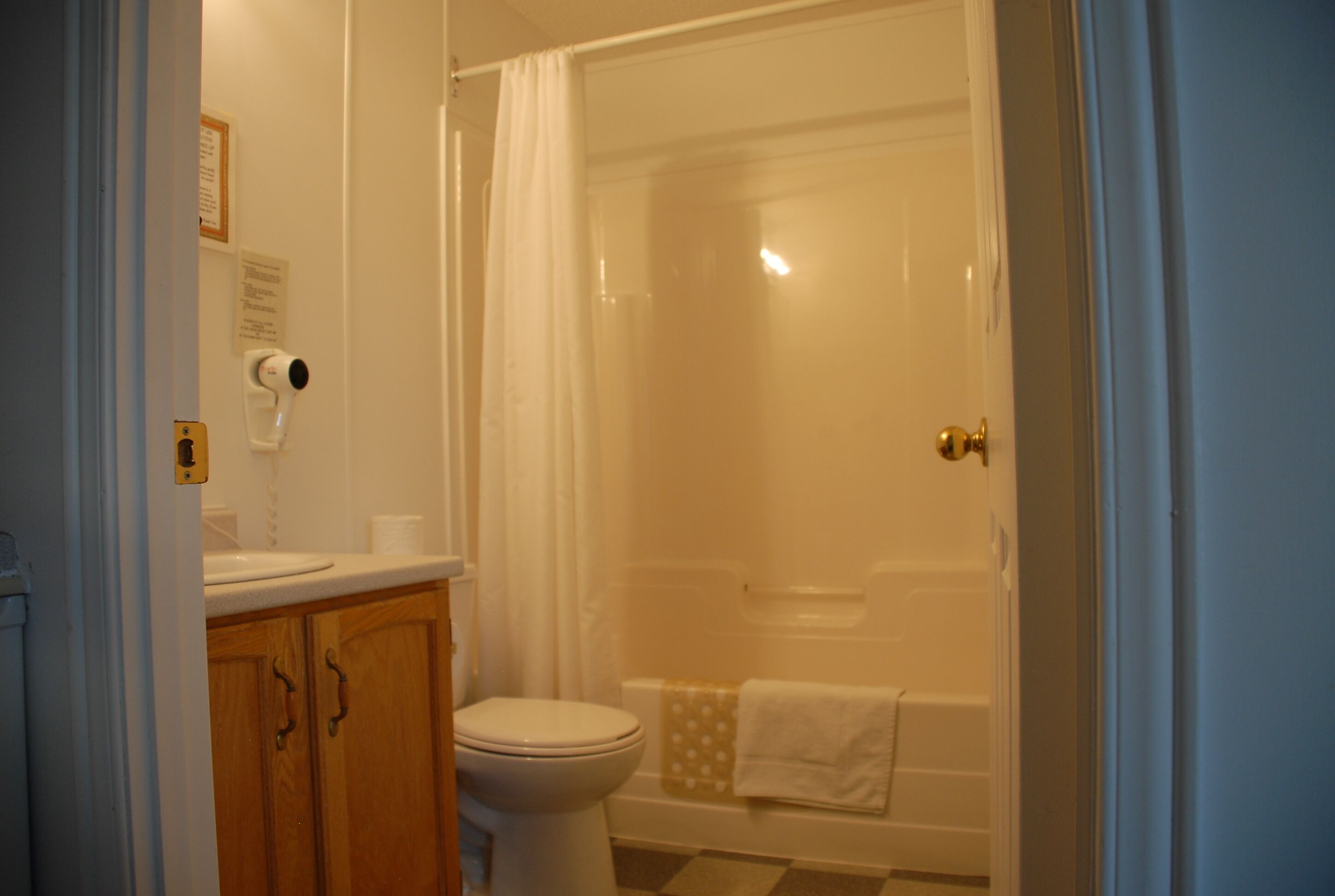 Un baño con inodoro, lavabo y zona de ducha.