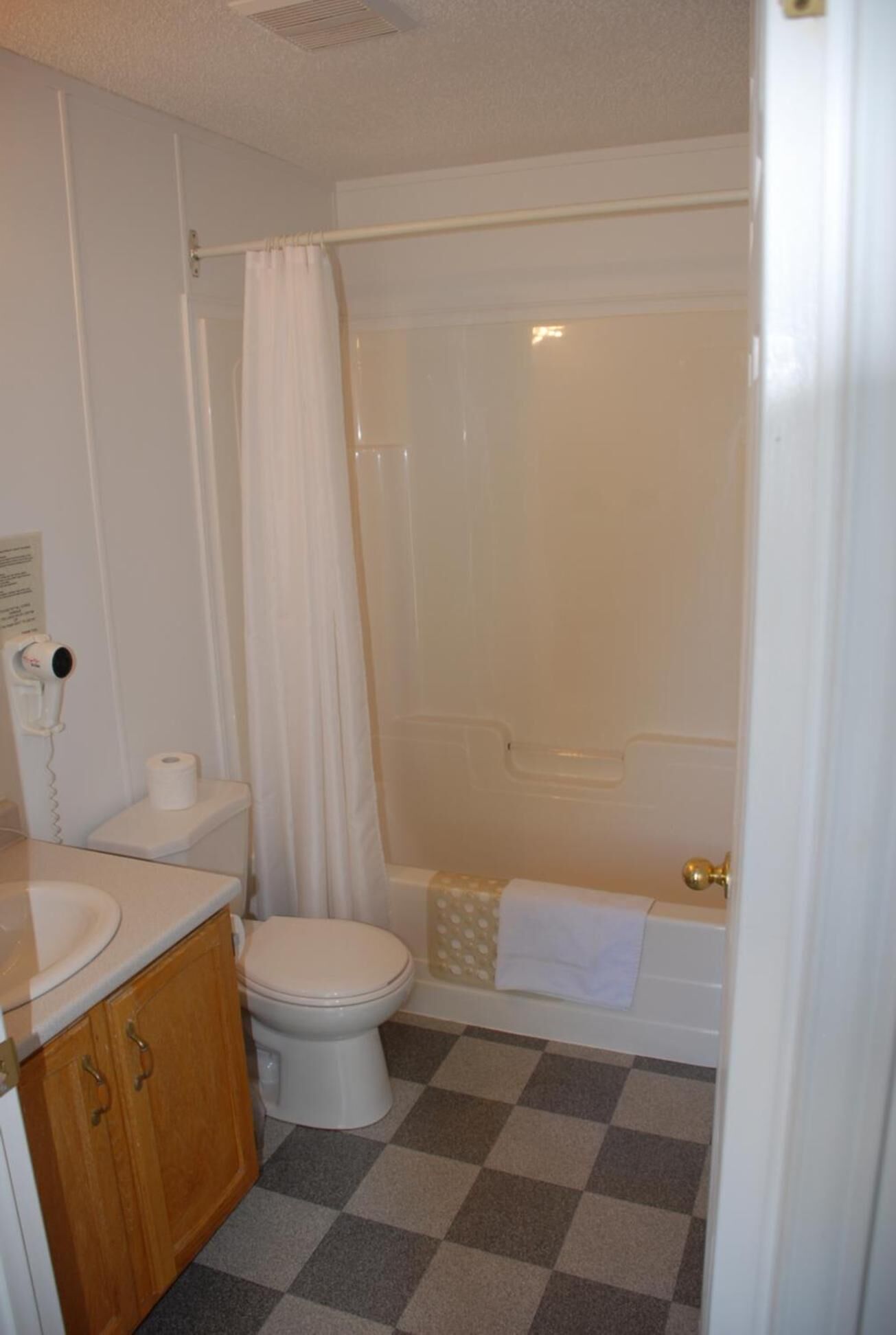 Un baño con inodoro, lavamanos y zona de ducha.