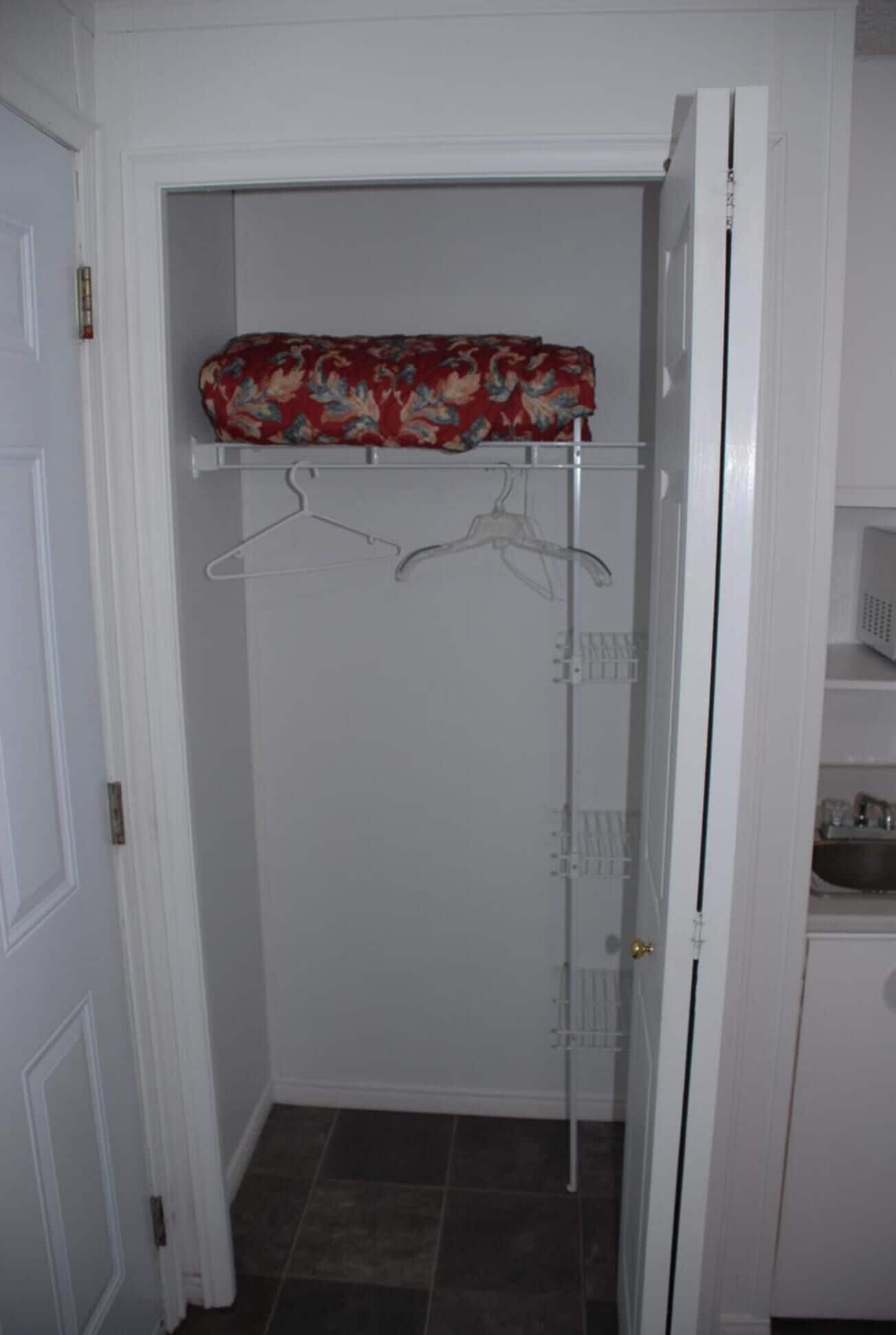 Un vestidor con barra para colgar y estante.