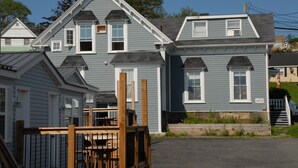 A row of two-story houses with gabled roofs and dormer windows. - Harbourview Motel & Accommodations (Port Hawkesbury)