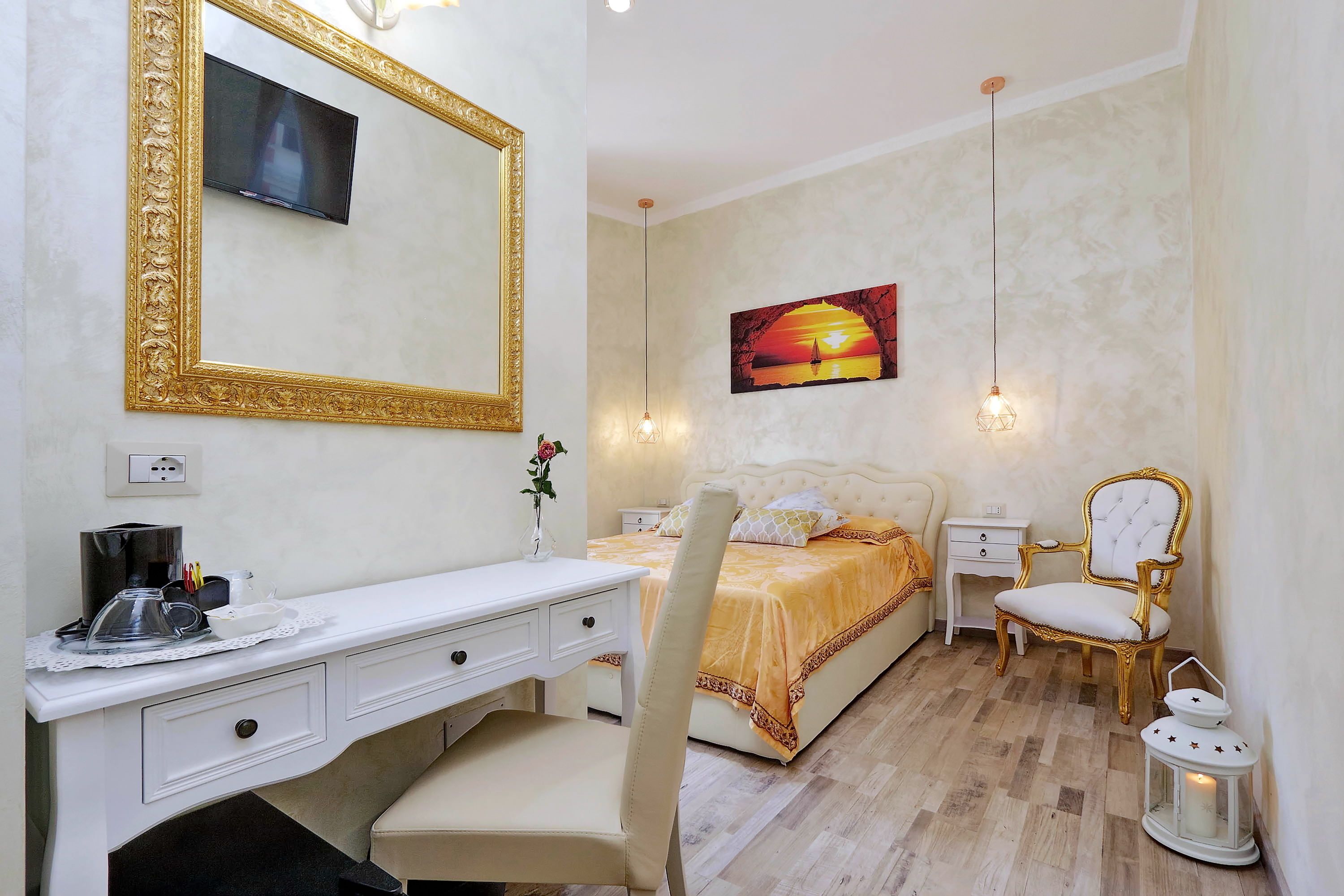 Une chambre à coucher avec un lit, un bureau, une chaise, un téléviseur et un tableau accroché au mur.