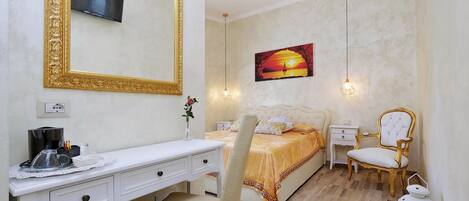 Une chambre à coucher avec un lit, un bureau, une chaise, un téléviseur et un tableau accroché au mur.
