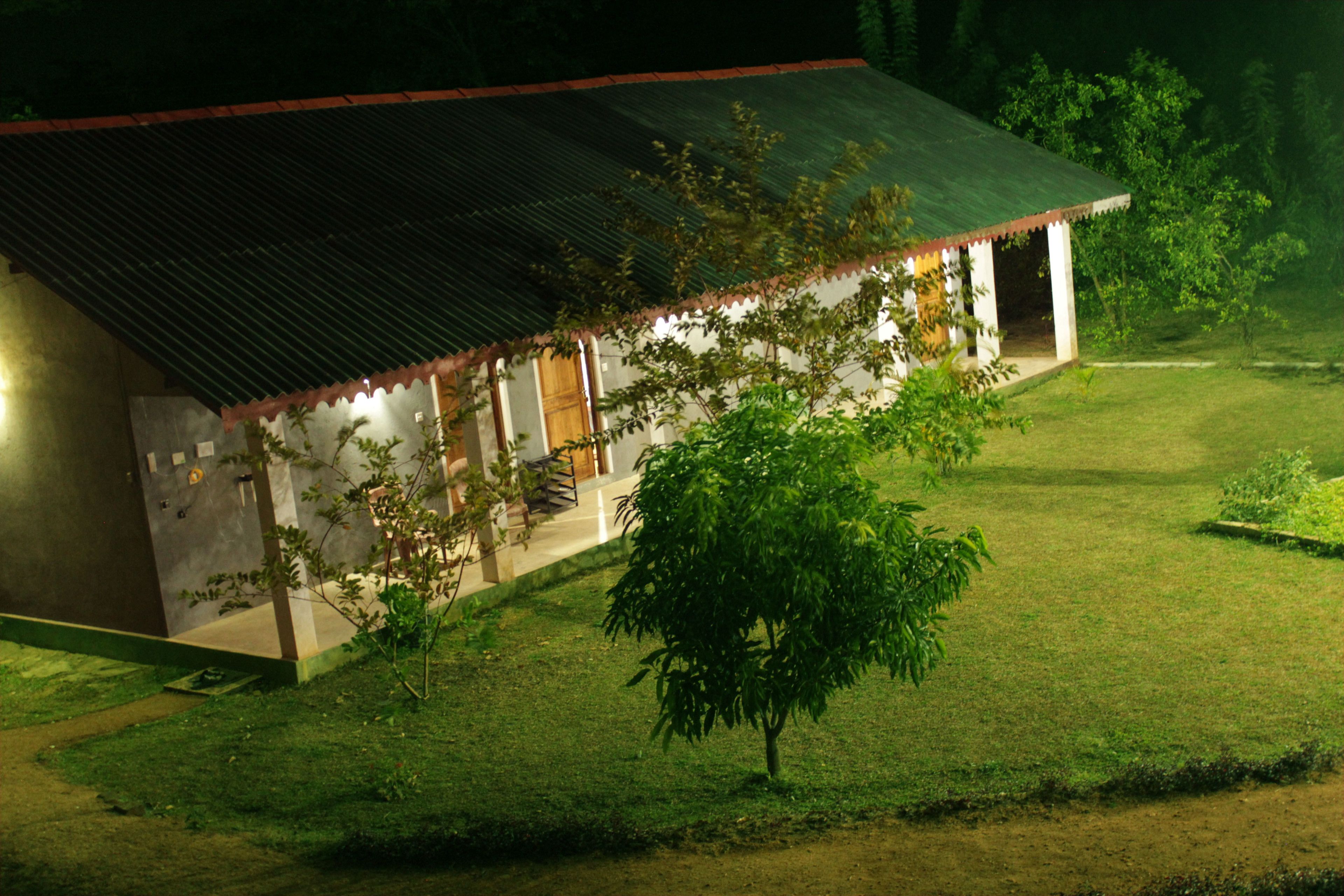 A single-story building with a sloped roof, surrounded by a well-maintained lawn and a few trees.