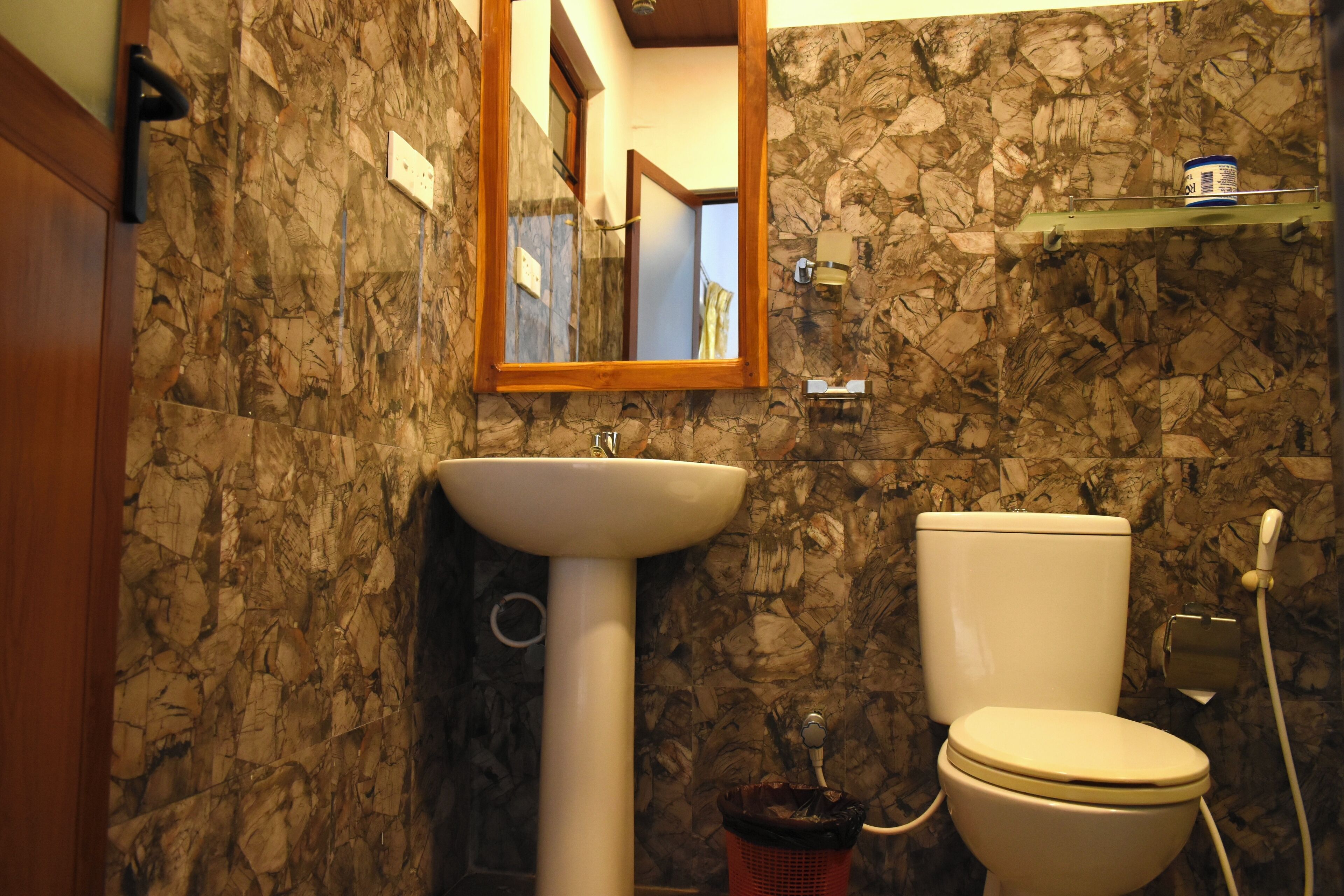 Un baño con pared de piedra, un lavamanos y un inodoro.