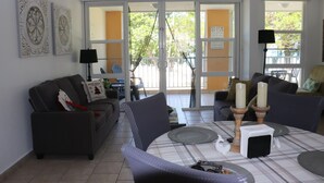 Una sala de estar con un sofá, sillones, una mesa de centro y una mesa de comedor.