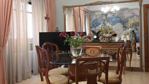 A dining area with a chandelier, a TV, and a floral painting on the wall. - 4 bedrooms appartmts (València)
