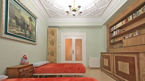 A room with two beds, a bookshelf, a painting, and a chandelier. - 4 bedrooms appartmts (València)