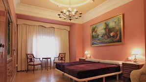 A bedroom with a bed, two chairs, a dresser, a painting, and a chandelier. - 4 bedrooms appartmts (València)