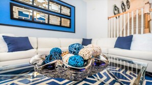 A modern living room with a white sofa, decorative balls, and a glass coffee table.