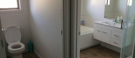 Ein Badezimmer mit Toilette, Waschbecken und Spiegel.