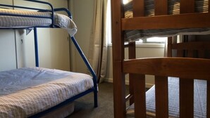 A bunk bed room with a wooden chair in the foreground.