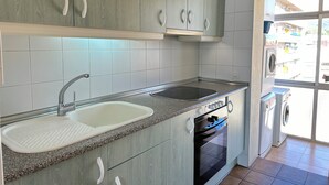 A modern kitchen with a granite countertop, stainless steel sink, and built-in oven. - Agi Solimar C Atico B Apartamento for rent in Roses Girona. (Rosas / Roses)