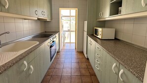 A kitchen with granite countertops, white cabinets, a sink, a stove, and a microwave. - Agi Solimar C Atico B Apartamento for rent in Roses Girona. (Rosas / Roses)