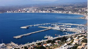An aerial view of a coastal marina with multiple piers, boats, and a marina building. - Agi Solimar C Atico B Apartamento for rent in Roses Girona. (Rosas / Roses)