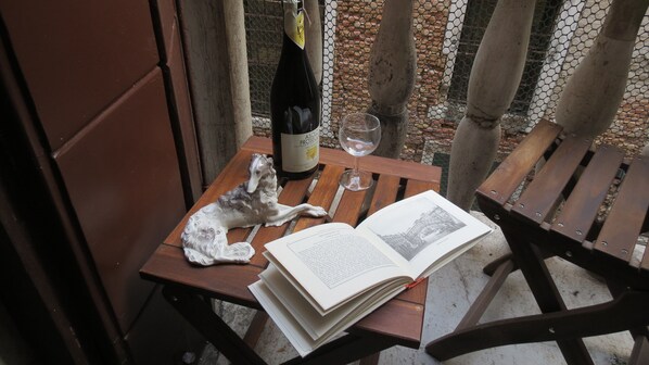 Une table en bois avec un livre, une bouteille de vin et un verre.