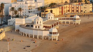A coastal building with a curved facade, multiple domed structures, and a beach in the foreground. - ATLANTICO Family Home by Cadiz4Rentals (Cádiz)