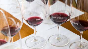 Wine glasses on a table with a menu titled "INKWELL Vintage Tasting Experience".
