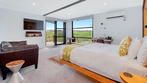 A modern bedroom with a large bed, a sofa, a desk, and a view of the outdoors. - Hotel California Road at Inkwell Wines (Tatachilla)